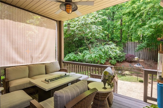 wooden deck with an outdoor living space, fence, and ceiling fan