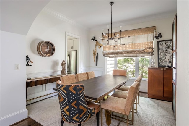 dining area featuring a chandelier and crown molding