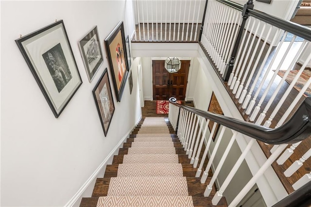 stairway with baseboards and wood finished floors