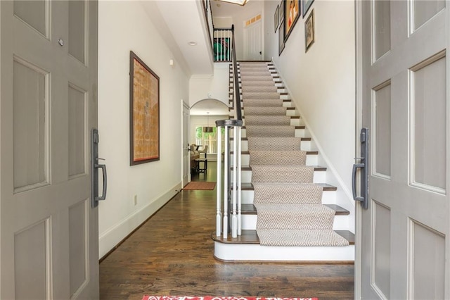 entrance foyer featuring stairs, wood finished floors, and baseboards