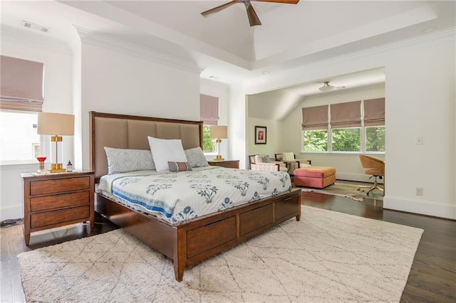 bedroom featuring crown molding, wood finished floors, baseboards, a tray ceiling, and ceiling fan