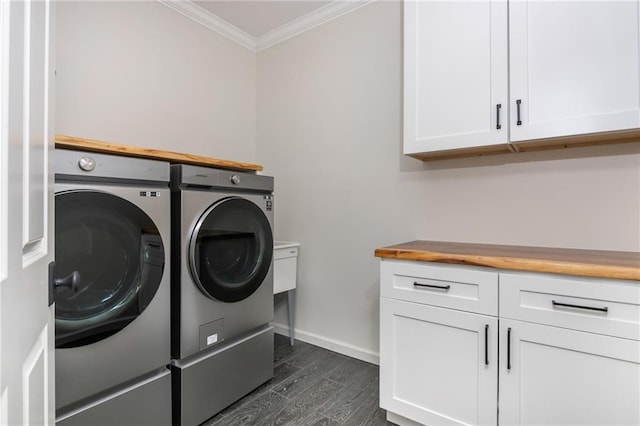 laundry area with washer and clothes dryer, ornamental molding, cabinet space, baseboards, and dark wood finished floors