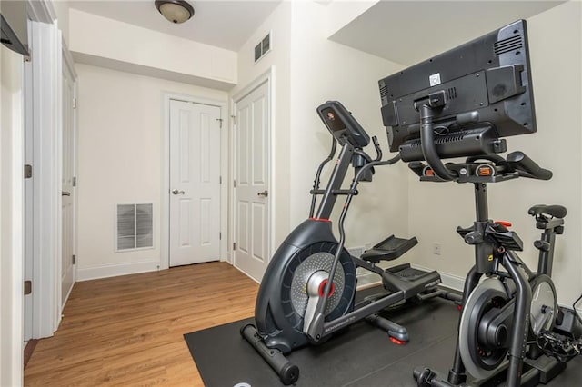 workout room featuring wood finished floors and baseboards