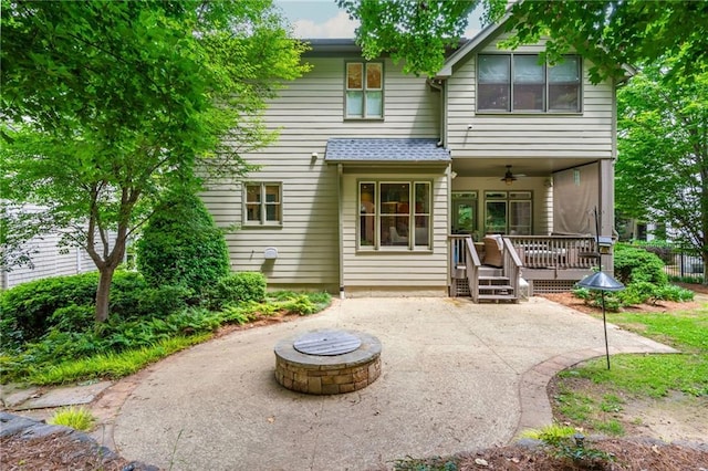 back of house with ceiling fan, a fire pit, a patio area, and a deck