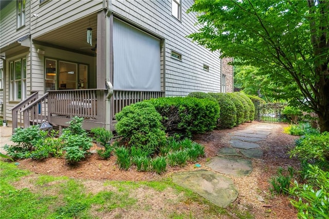 view of side of property with a porch and a gate