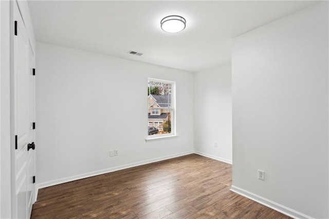 unfurnished bedroom featuring visible vents, dark wood finished floors, and baseboards