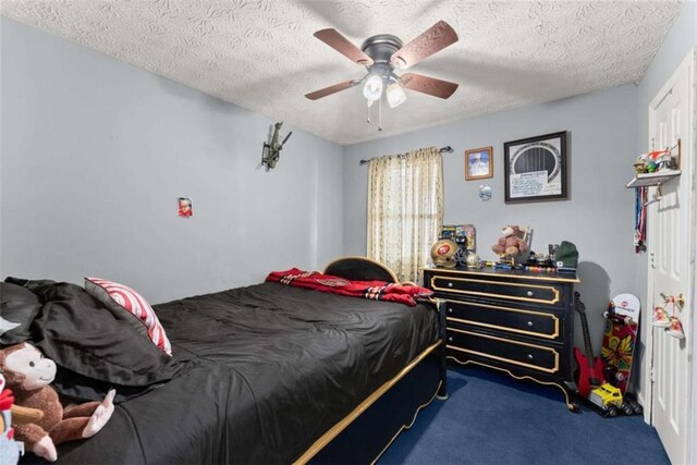 bedroom with a ceiling fan, dark colored carpet, and a textured ceiling