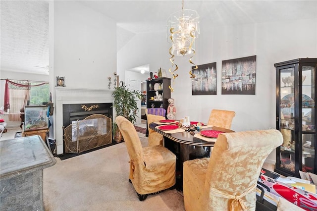 dining area featuring carpet floors, a glass covered fireplace, a chandelier, and vaulted ceiling