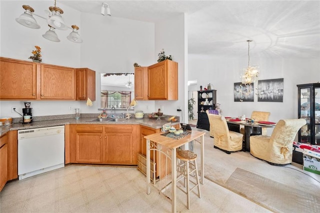 kitchen featuring white dishwasher, a sink, pendant lighting, light floors, and a chandelier