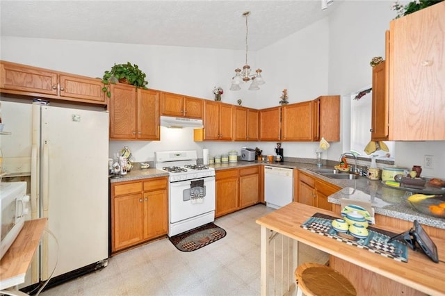 kitchen with white appliances, under cabinet range hood, a sink, high vaulted ceiling, and light floors