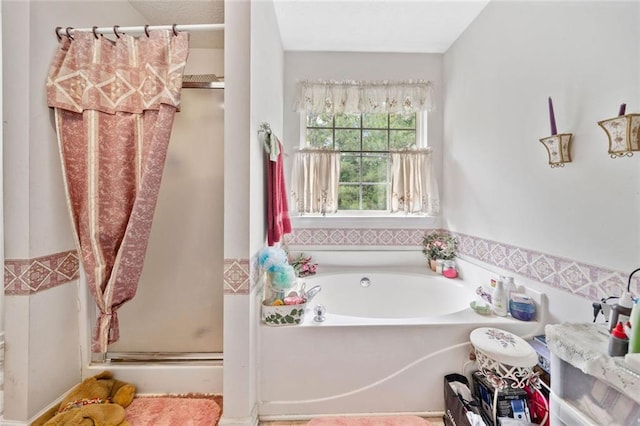 bathroom featuring a shower stall and a bath