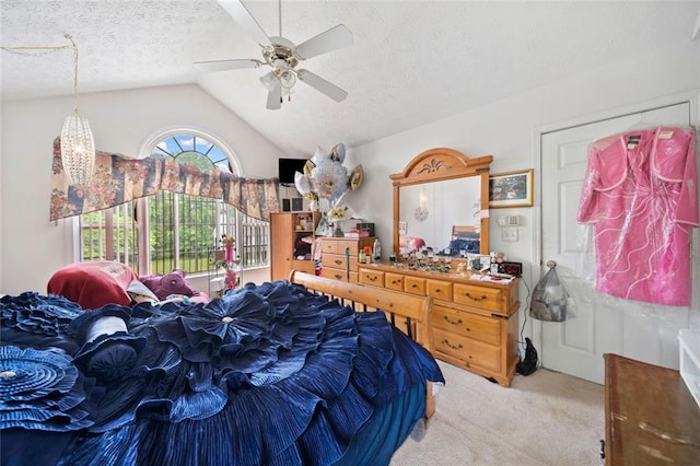 carpeted bedroom with lofted ceiling, a textured ceiling, and a ceiling fan