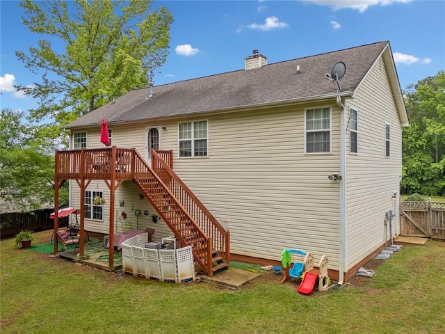 rear view of property with a deck, a chimney, stairway, and roof with shingles