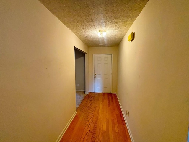 hall featuring hardwood / wood-style flooring and a textured ceiling