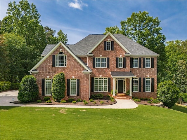 view of front of house featuring a front yard and brick siding