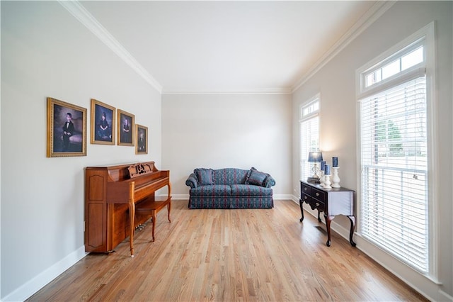 living area featuring light wood-style flooring, ornamental molding, and baseboards