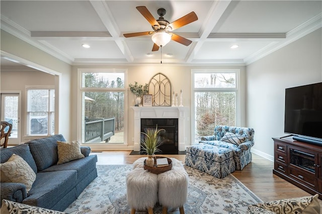 living room featuring plenty of natural light, coffered ceiling, a fireplace with flush hearth, wood finished floors, and beamed ceiling