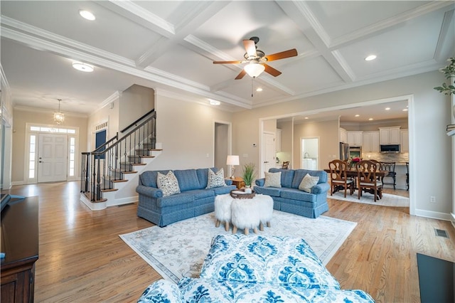 living area featuring light wood-type flooring, stairs, coffered ceiling, beamed ceiling, and ornamental molding
