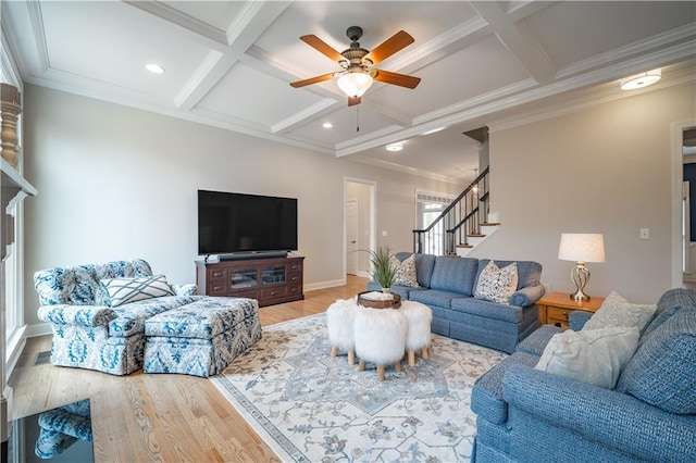 living room featuring coffered ceiling, wood finished floors, stairs, a ceiling fan, and beam ceiling