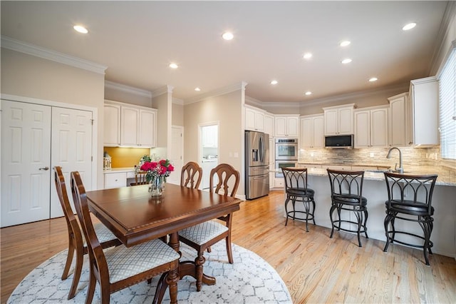 dining space with washer / dryer, crown molding, light wood-style flooring, and recessed lighting