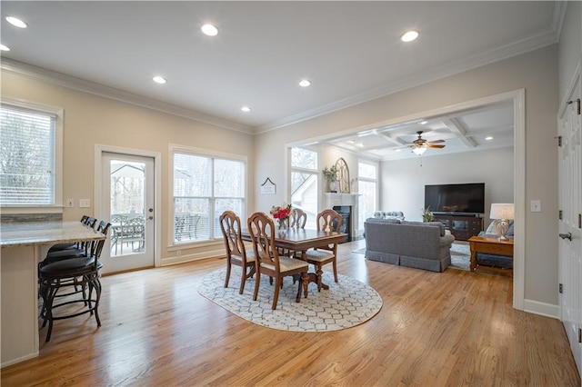 dining room featuring light wood-style flooring, coffered ceiling, recessed lighting, a fireplace, and crown molding