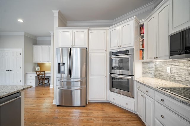 kitchen featuring appliances with stainless steel finishes, light wood finished floors, light stone counters, ornamental molding, and white cabinets