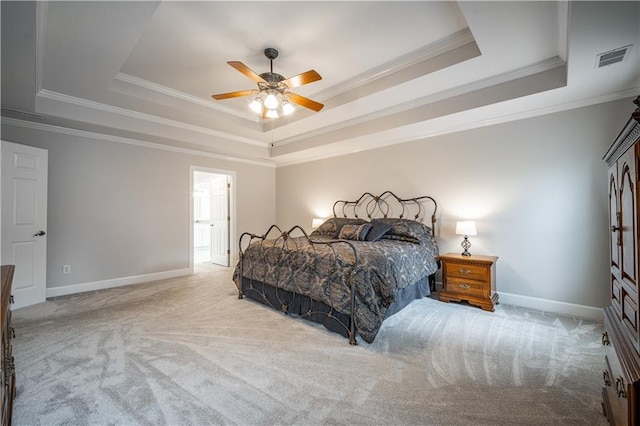 bedroom with a tray ceiling, carpet floors, crown molding, baseboards, and a ceiling fan