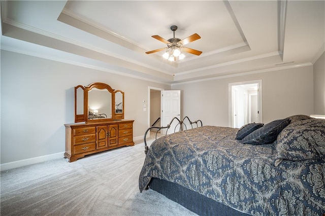 bedroom featuring a tray ceiling, ornamental molding, light carpet, baseboards, and ceiling fan