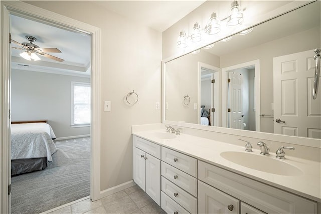 ensuite bathroom featuring baseboards, double vanity, a ceiling fan, and ornamental molding