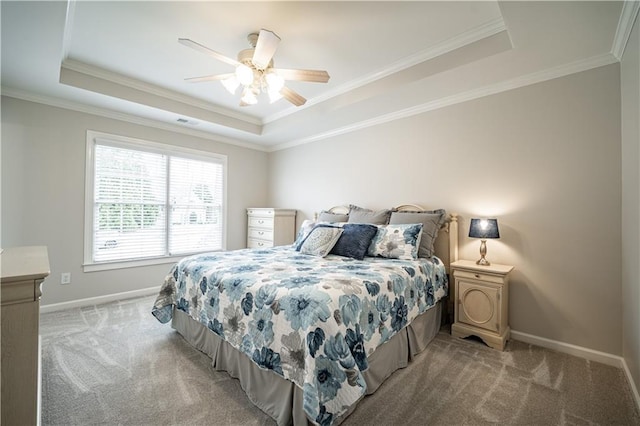 bedroom with a tray ceiling, light carpet, crown molding, baseboards, and ceiling fan