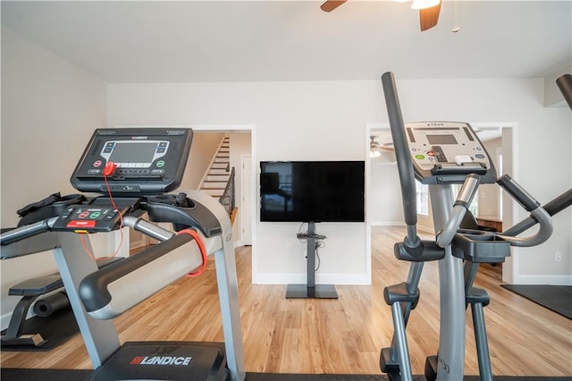 exercise area with a ceiling fan, wood finished floors, and baseboards