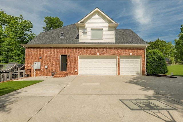 view of side of property featuring driveway, brick siding, and a shingled roof