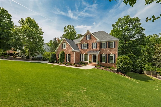 colonial home with brick siding and a front lawn