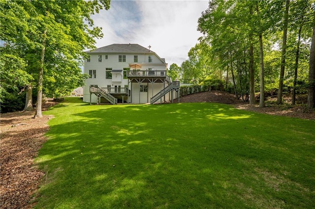 view of grassy yard with stairway and a deck