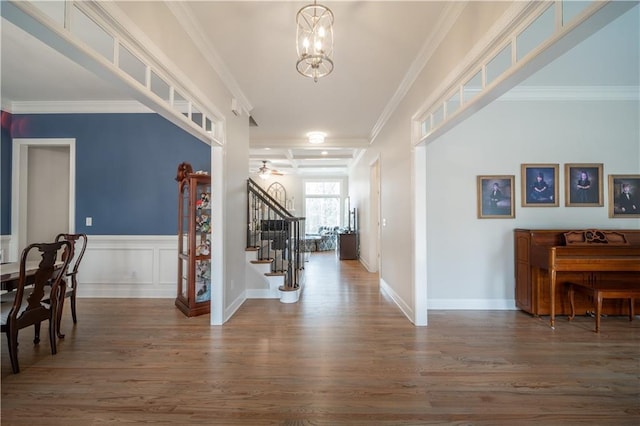 entrance foyer featuring stairway, wood finished floors, a chandelier, ornamental molding, and baseboards