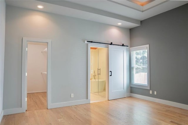 3050 Baymount Dr, Lawrenceville, GA 30043 - unfurnished bedroom featuring a spacious closet, wood finished floors, a barn door, recessed lighting, and ensuite bath