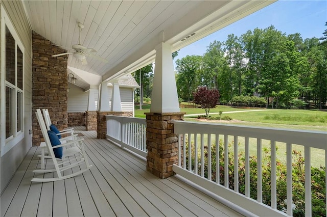 deck with a porch, ceiling fan, and a yard