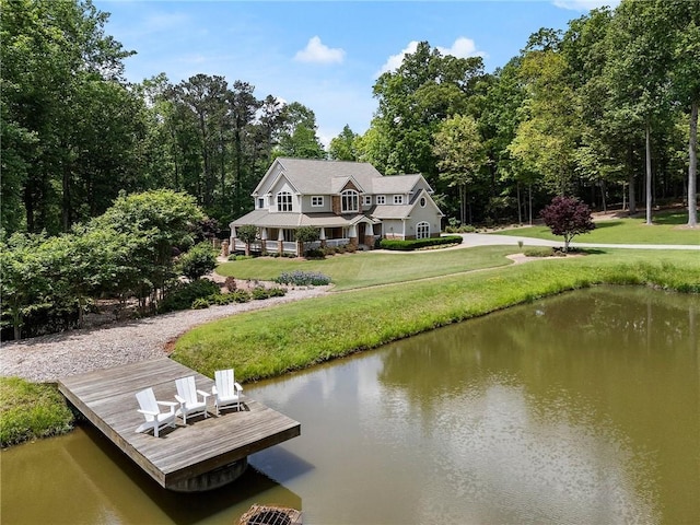 dock area with a lawn and a water view