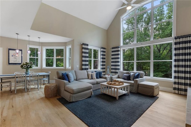 living room featuring light wood-type flooring, a healthy amount of sunlight, and high vaulted ceiling