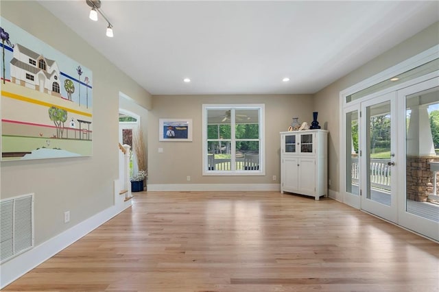 interior space with light wood finished floors, french doors, recessed lighting, baseboards, and visible vents