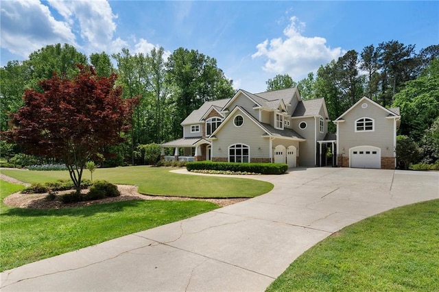 view of front of house with a garage, driveway, a front lawn, and stone siding