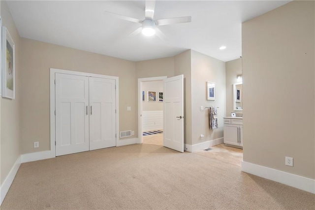 unfurnished bedroom featuring connected bathroom, light colored carpet, baseboards, and visible vents