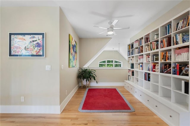 living area featuring vaulted ceiling, ceiling fan, baseboards, and wood finished floors