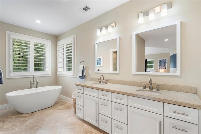 bathroom featuring visible vents, baseboards, and a sink