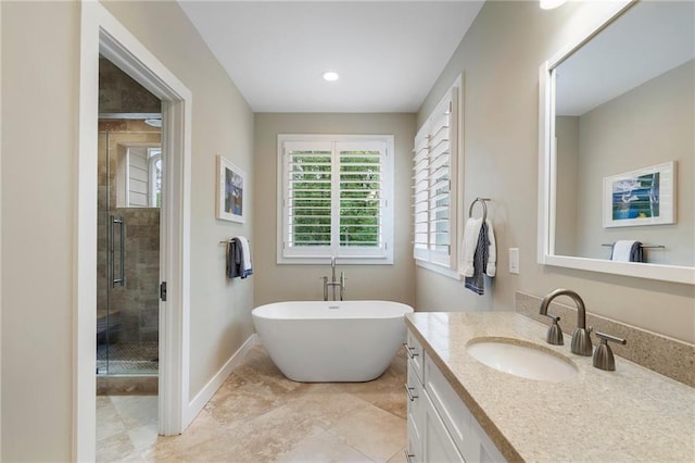 full bathroom with vanity, baseboards, tile patterned floors, a freestanding bath, and a shower stall