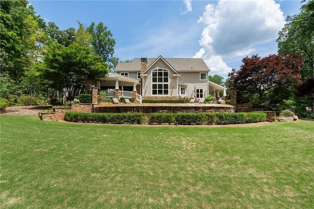 rear view of house with a lawn and a chimney