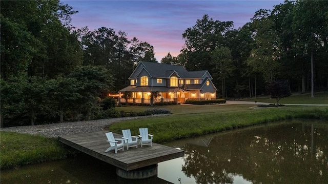 back of property with a yard and a water view
