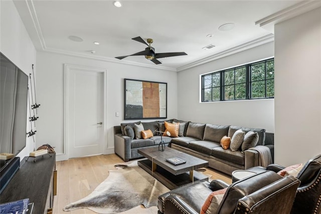 living room featuring light wood finished floors, visible vents, a ceiling fan, and ornamental molding