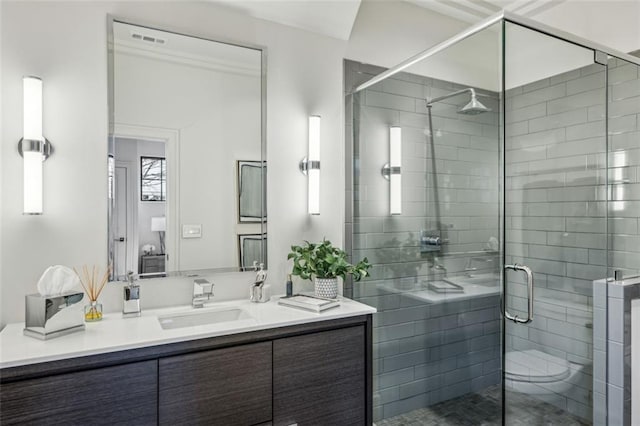 full bathroom featuring visible vents, a shower stall, and vanity