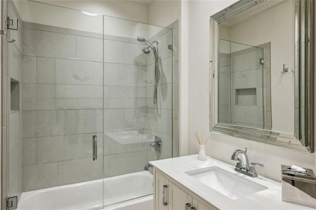 bathroom featuring combined bath / shower with glass door and vanity